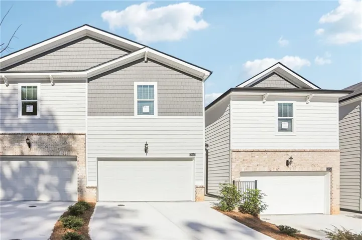 Modern two-story homes featuring clean-lined architectural design with peaked rooflines, fiber cement siding in neutral tones, and brick-and-stone exterior accents