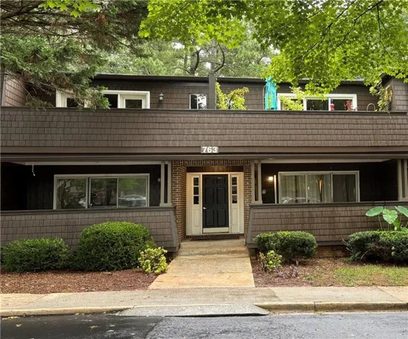 Multi-level exterior featuring wood shingle siding and dark trim