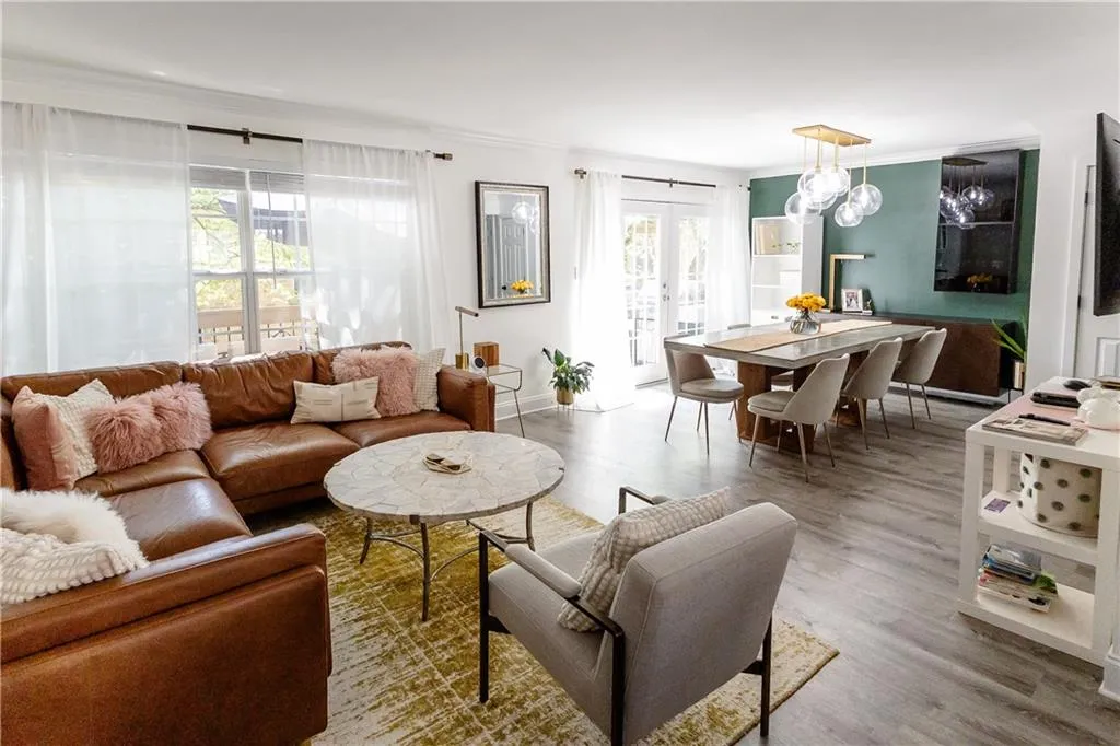 Living room with crown molding, french doors, a healthy amount of sunlight, and hardwood / wood-style floors