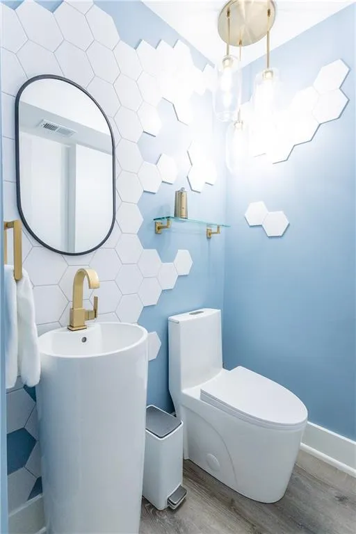 Bathroom featuring toilet, wood-type flooring, and tasteful backsplash