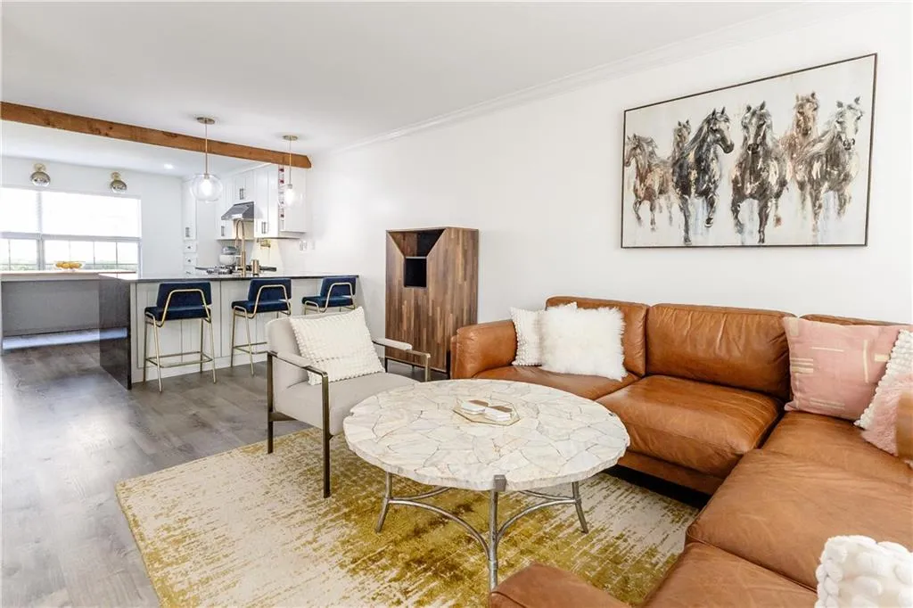 Living room with ornamental molding and hardwood / wood-style floors