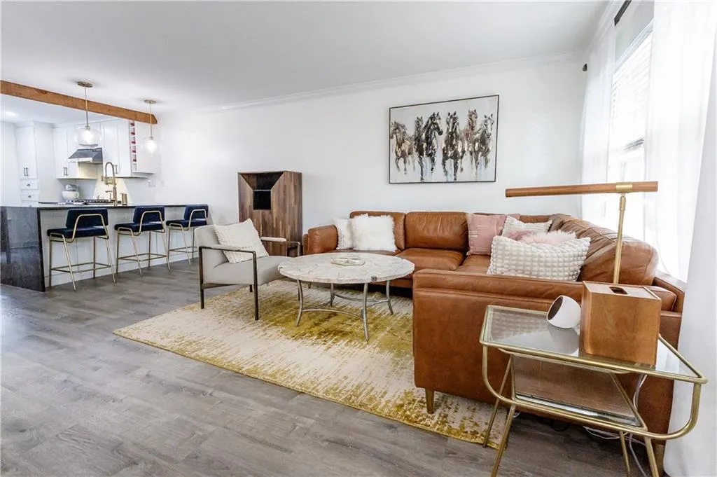Living room featuring a wealth of natural light, ornamental molding, and wood-type flooring