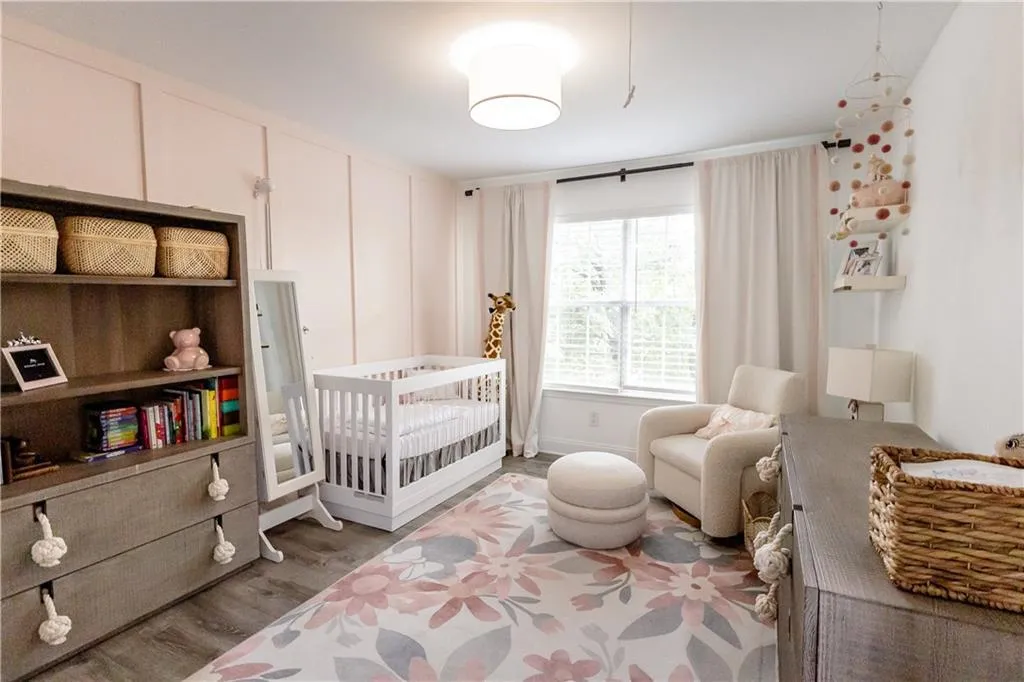 Bedroom featuring light wood-type flooring and a crib