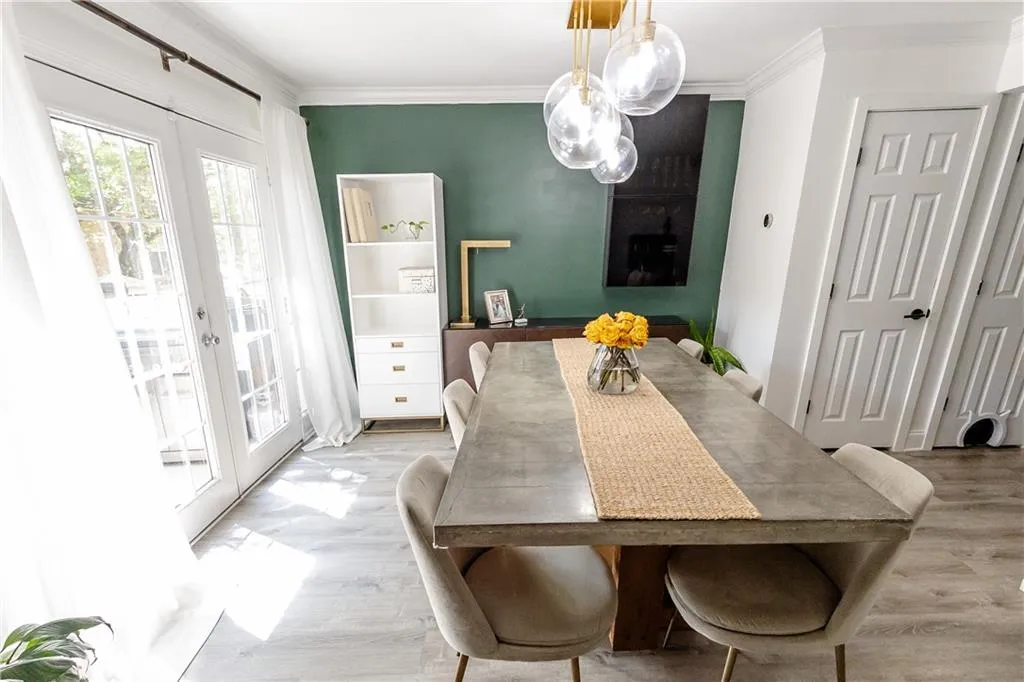 Dining area with light wood-type flooring, french doors, and ornamental molding