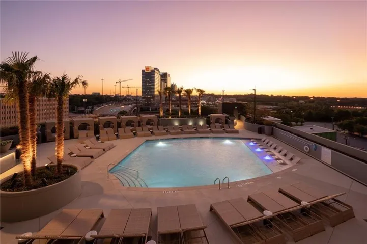 Pool at dusk featuring a community pool