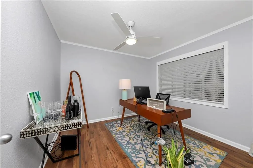 Office featuring ornamental molding, dark wood-type flooring, and ceiling fan