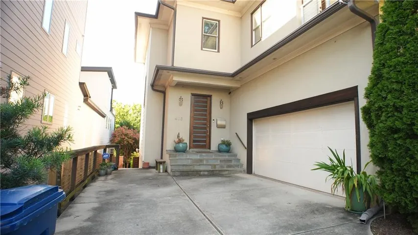 Stucco exterior with multi-level architecture and dark trim accents