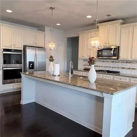 Kitchen featuring a large island with granite countertops and an undermount sink