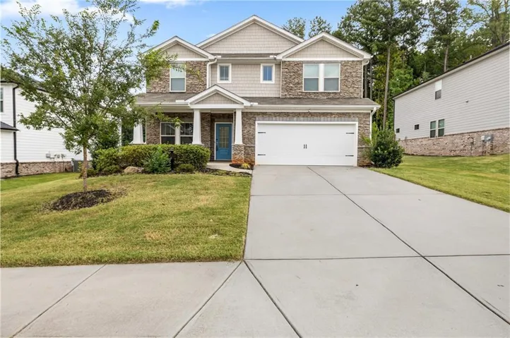 Two-story residence featuring a brick and siding exterior, an attached two-car garage, and a concrete driveway