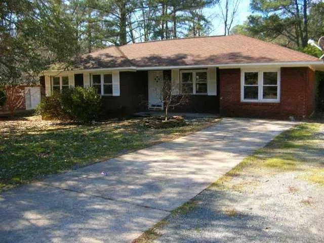 Brick and siding exterior featuring a brown shingle roof