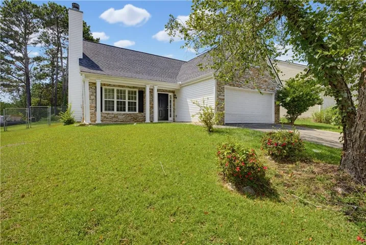 Exterior with stone veneer accents, white siding, a single-car garage, dark-framed windows, and a black front door