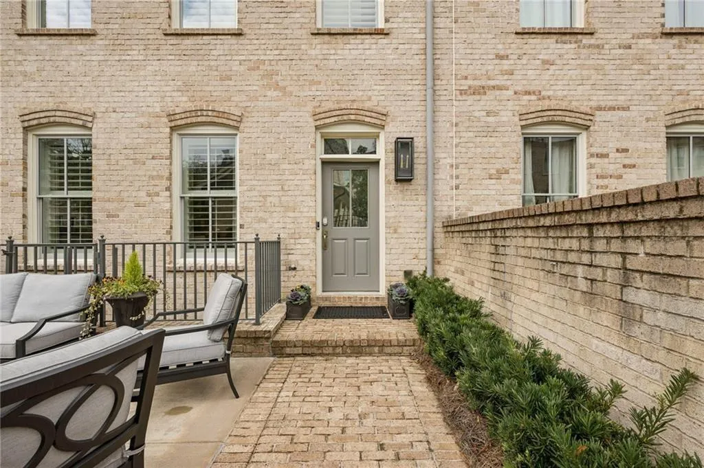 Brick exterior with an arched entryway and a gray paneled door