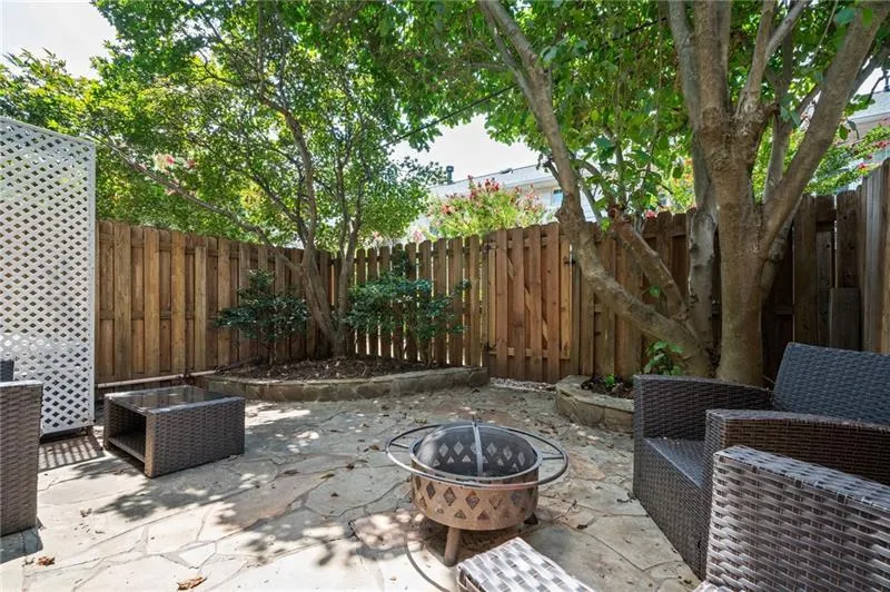 Fenced backyard with a fire pit and a patio area