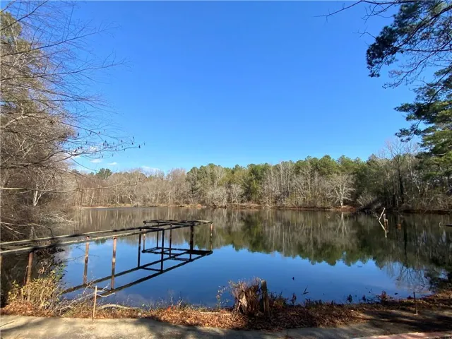 Dock featuring a forest view and a water view