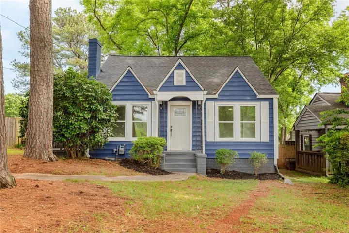 Blue siding exterior with white window trim and shutters, gray steps, and a dark shingled roof