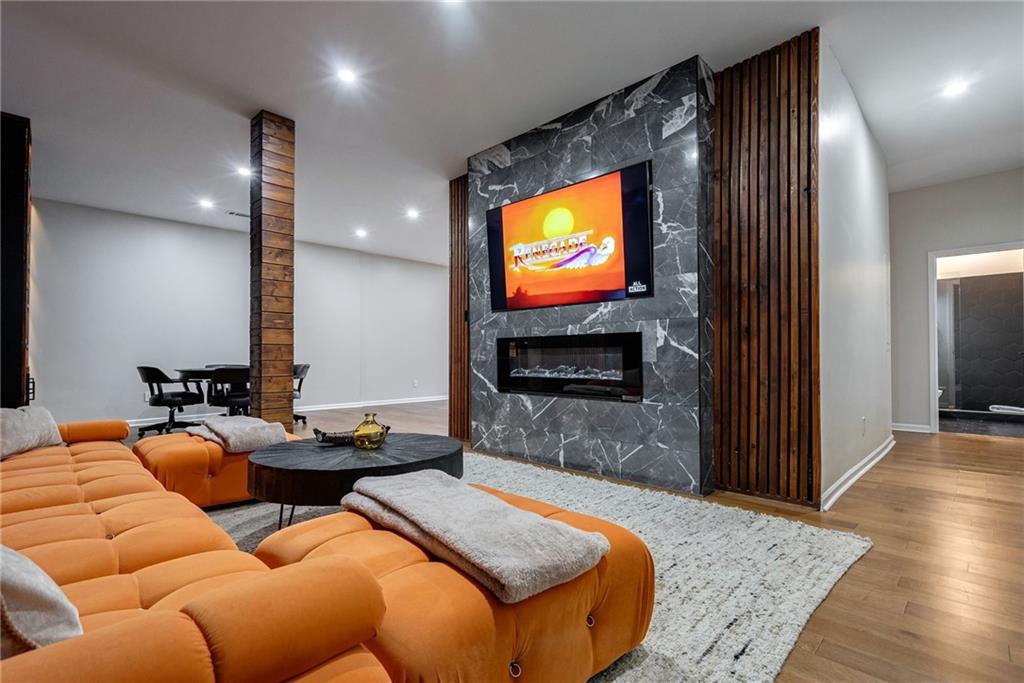 Cinema room with a fireplace and light wood-type flooring