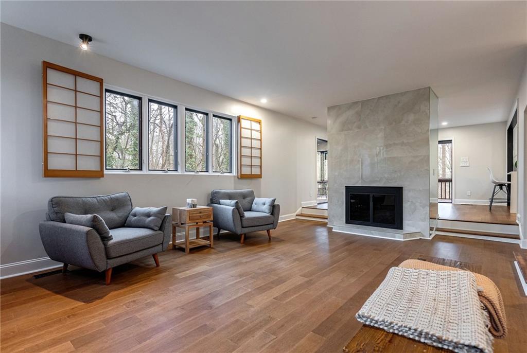 Living room with a fireplace and wood-type flooring