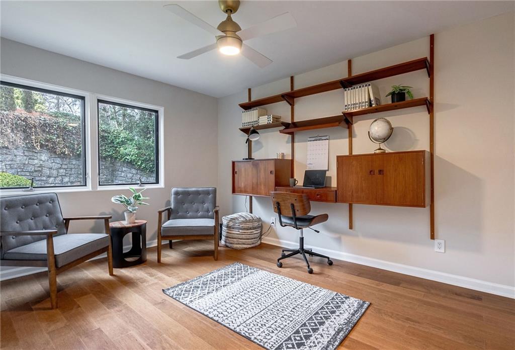 Office area with light hardwood / wood-style floors and ceiling fan