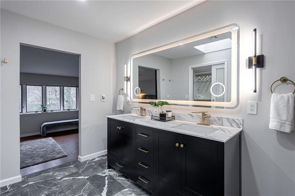 Bathroom with large vanity, tile floors, and double sink