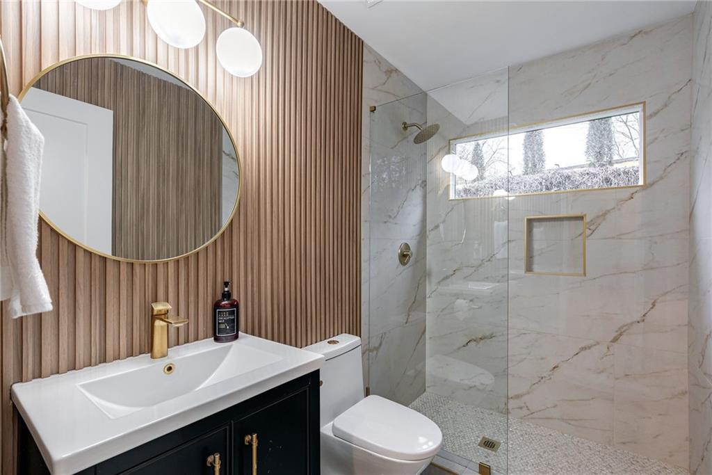 Bathroom with vanity, toilet, and an enclosed shower