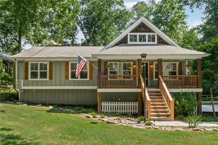 Craftsman-style exterior with a covered porch, wood-finished railing, exposed beam accents, and a dormer window