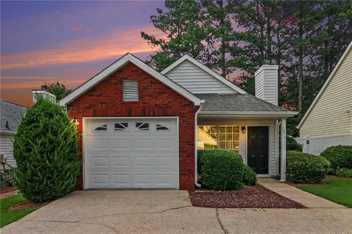 Red brick and siding exterior with an attached garage