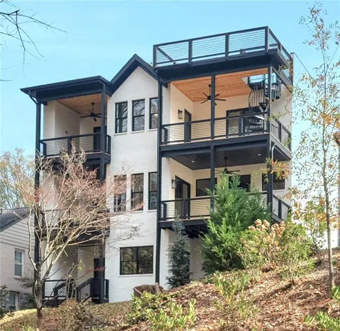 Rear of home showing 5 balcony decks all with incredible view of the private wooded rear yard.