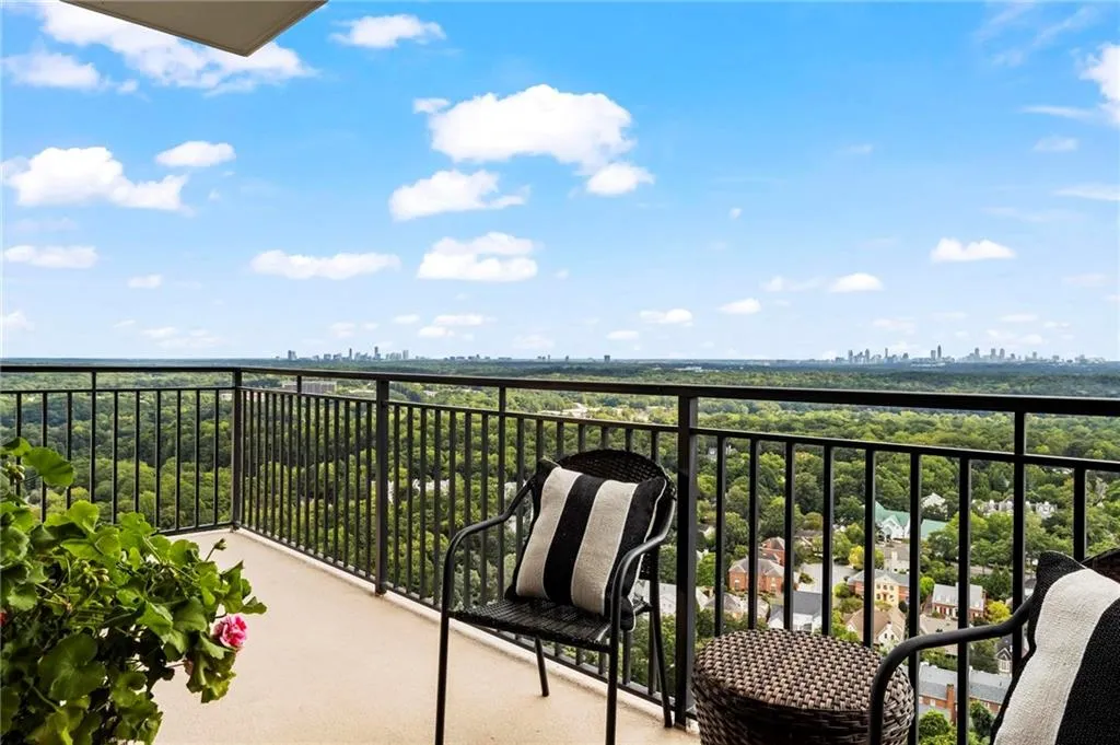 Expansive balcony featuring a metal railing and a distant cityscape