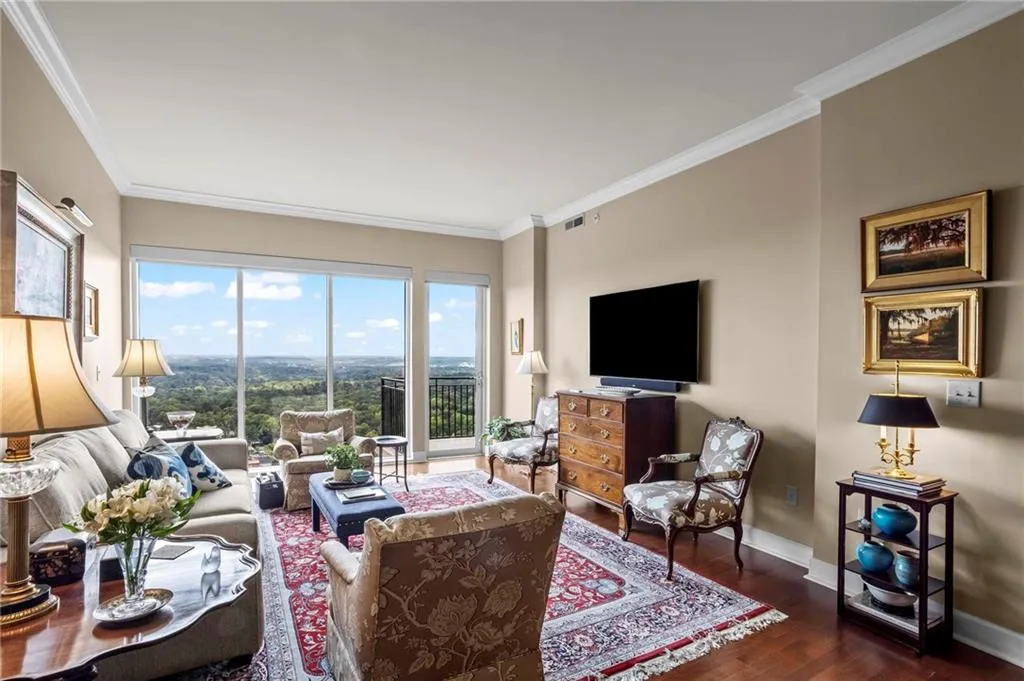 Expansive floor-to-ceiling windows, crown molding, and hardwood flooring