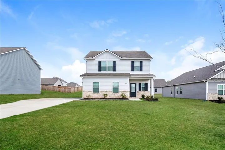 Two-story home with light-toned siding and dark shutters