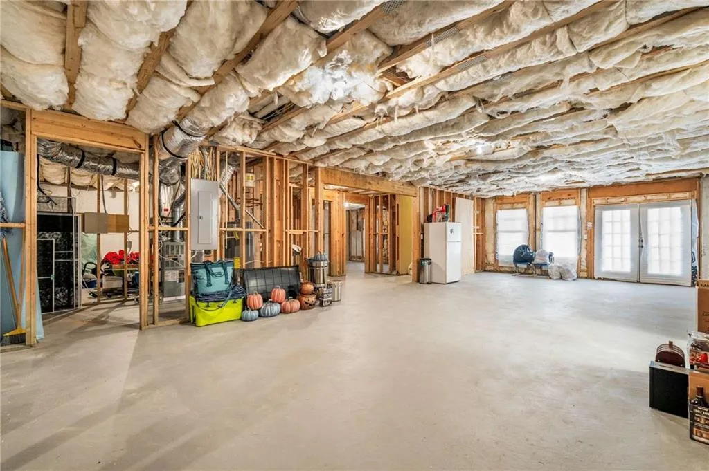 Below grade area featuring electric panel and freestanding refrigerator