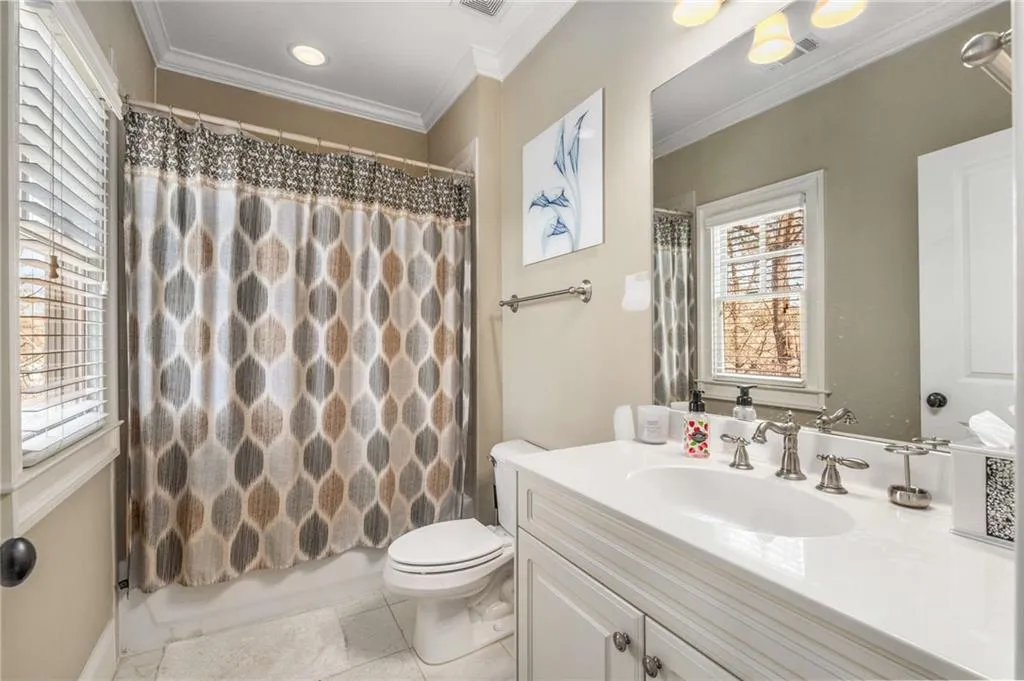Bathroom featuring visible vents, ornamental molding, vanity, and toilet