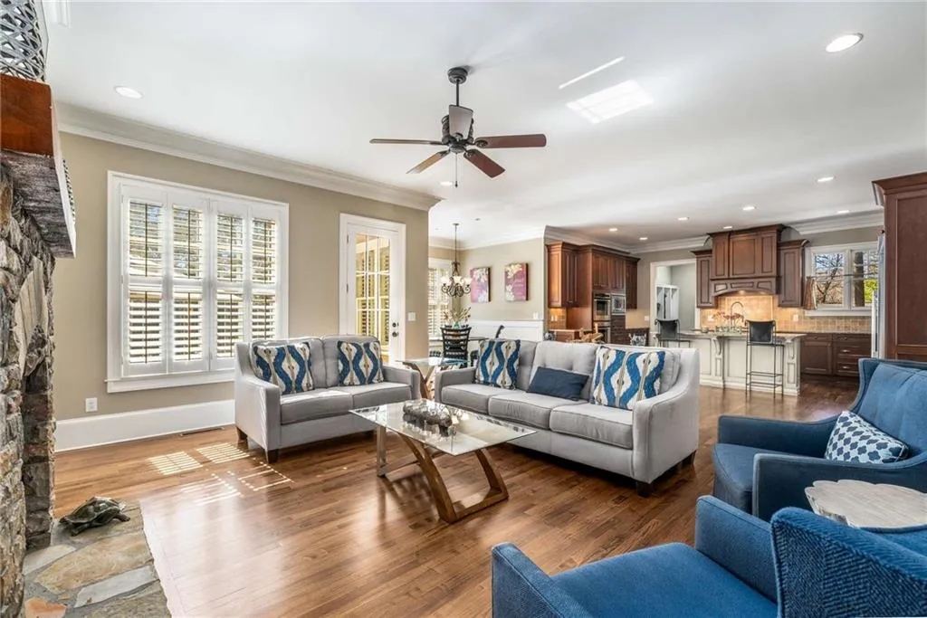 Living room featuring ornamental molding, dark wood-style flooring, plenty of natural light, and ceiling fan