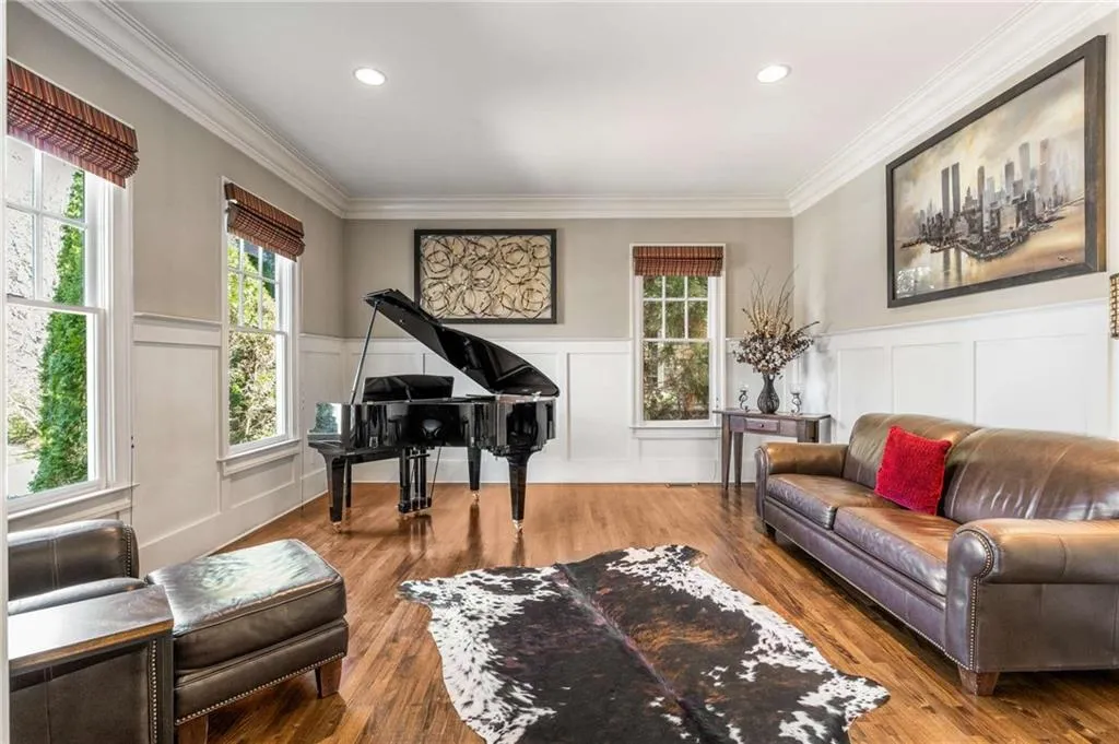 Living area featuring a wainscoted wall, recessed lighting, wood finished floors, and crown molding