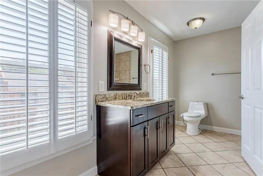 Bathroom with light tile patterned flooring and vanity