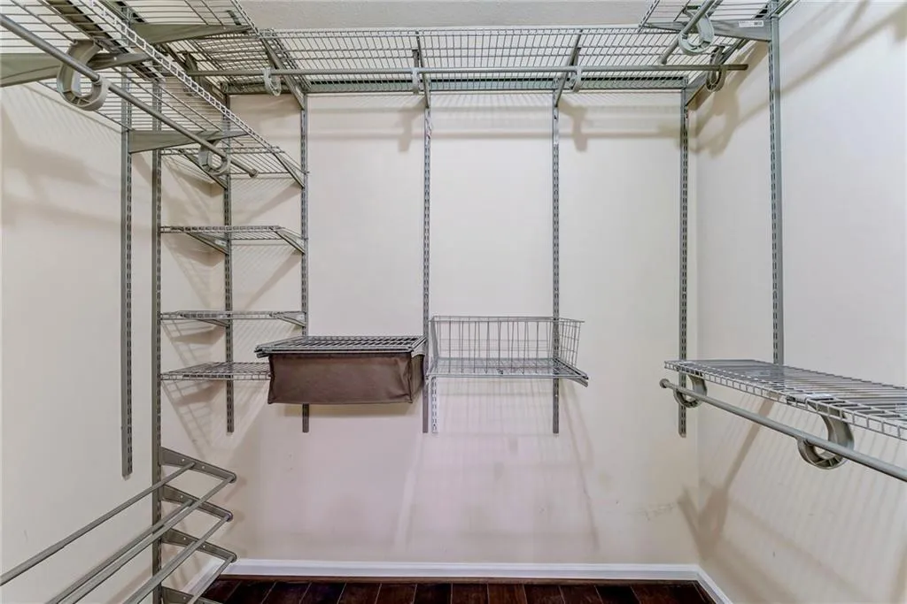 Walk in closet featuring dark wood-type flooring