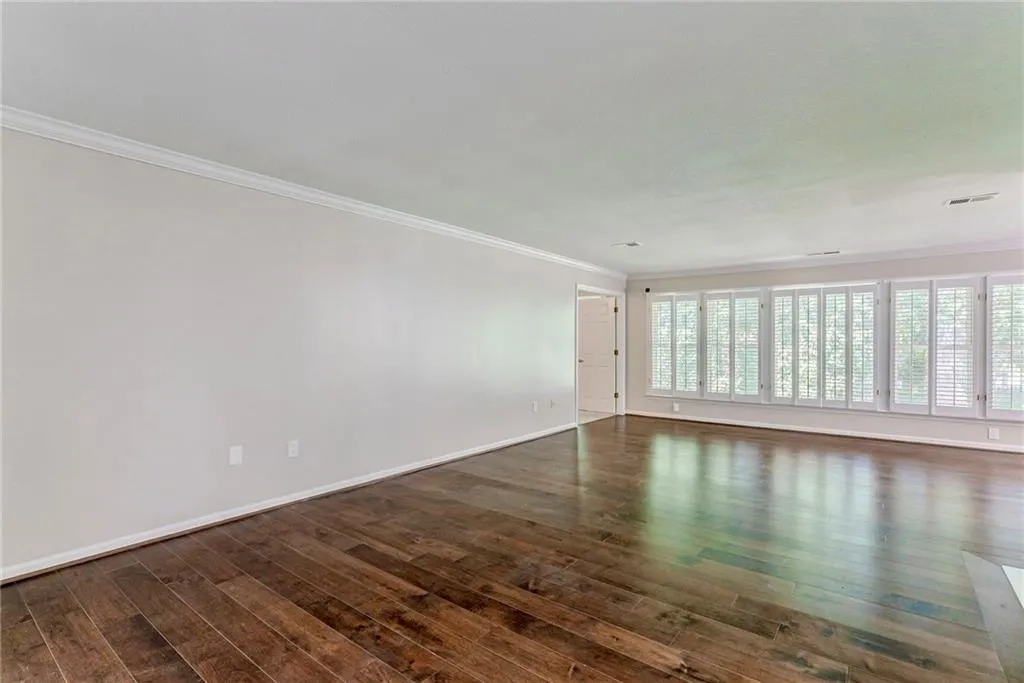 Spare room with ornamental molding and dark wood-style flooring