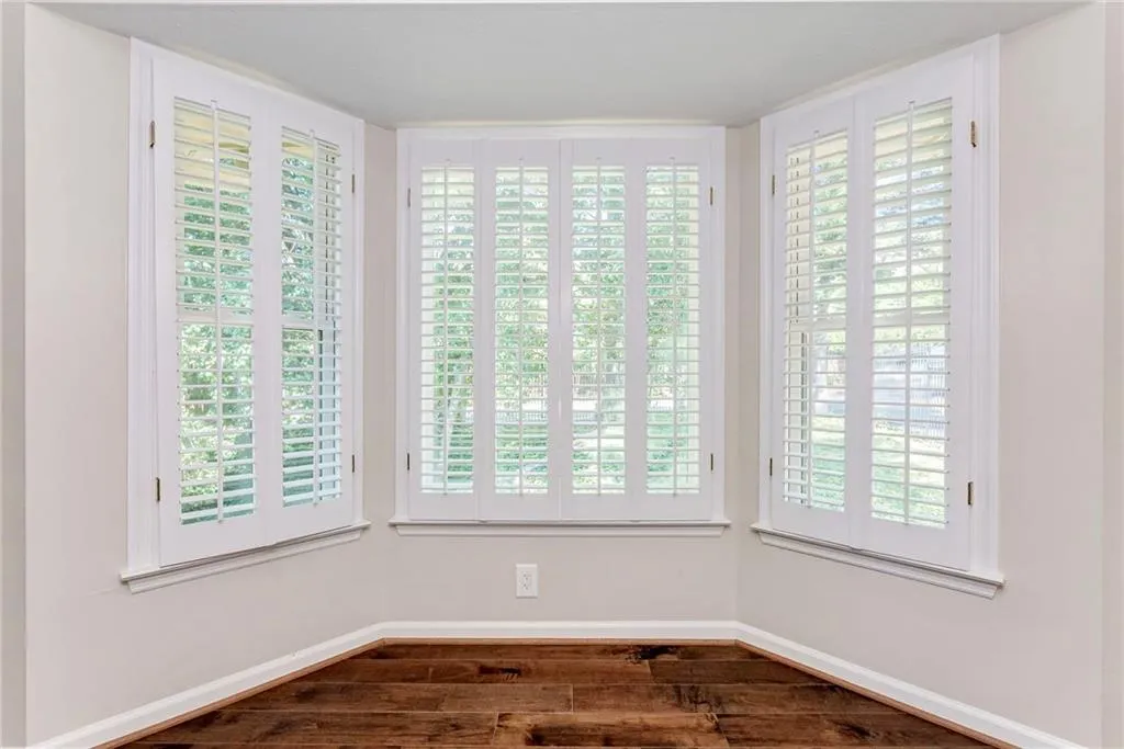 Empty room with healthy amount of natural light and dark wood-style floors