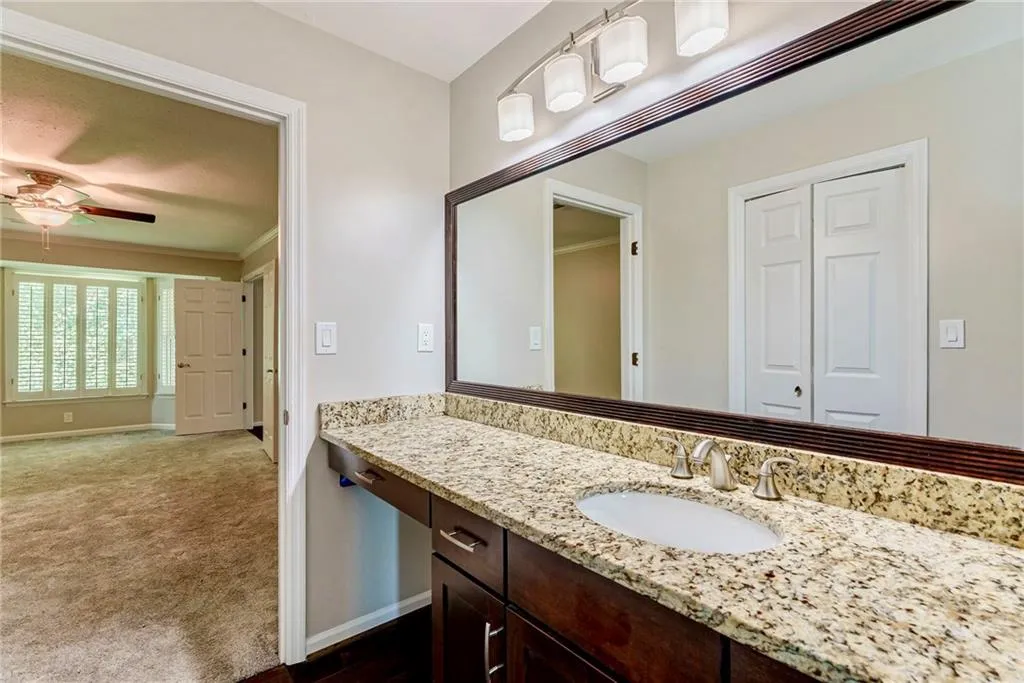 Bathroom with vanity, ceiling fan, and ornamental molding