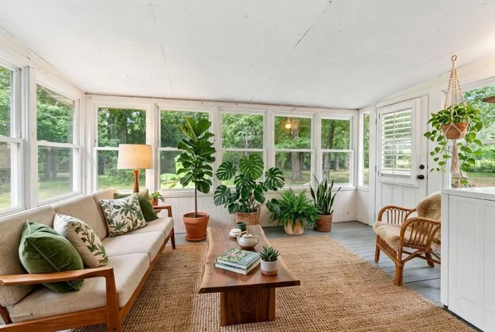 Sunroom featuring multiple windows, a white paneled ceiling, and painted flooring