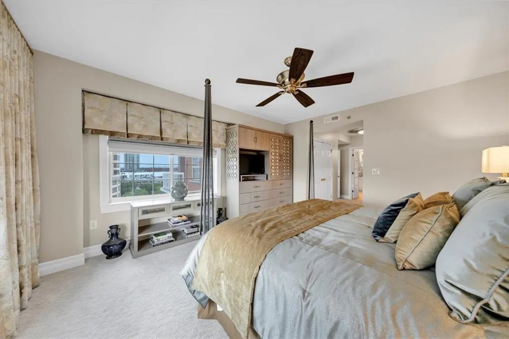 Primary bedroom with custom window blinds and draperies