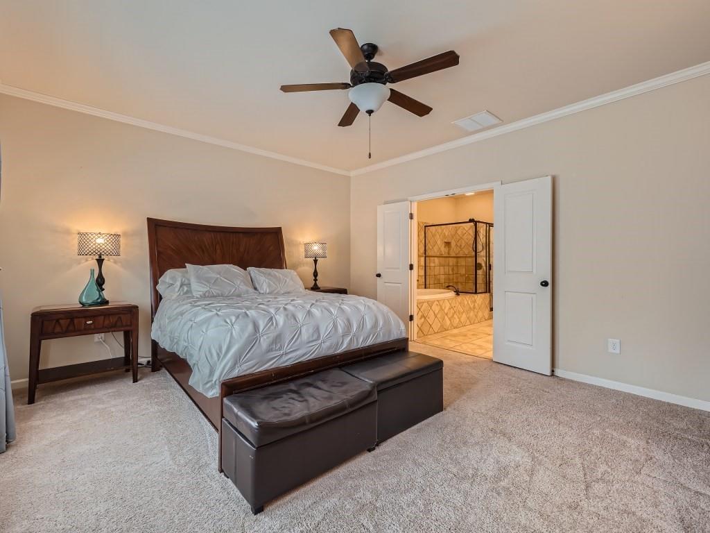 Bedroom featuring ensuite bathroom, crown molding, light carpet, and ceiling fan