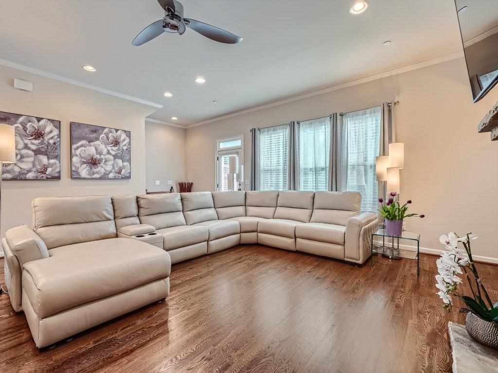 Living room featuring ornamental molding, dark hardwood / wood-style flooring, and ceiling fan