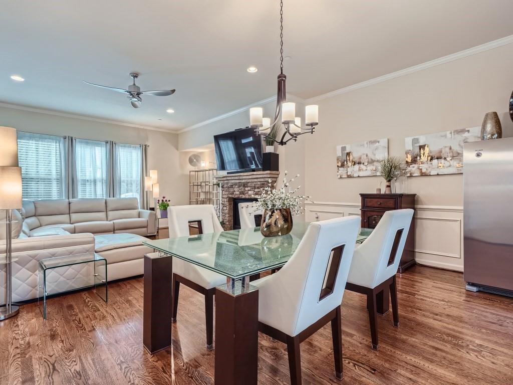 Dining area with a fireplace, dark hardwood / wood-style floors, ceiling fan with notable chandelier, and crown molding
