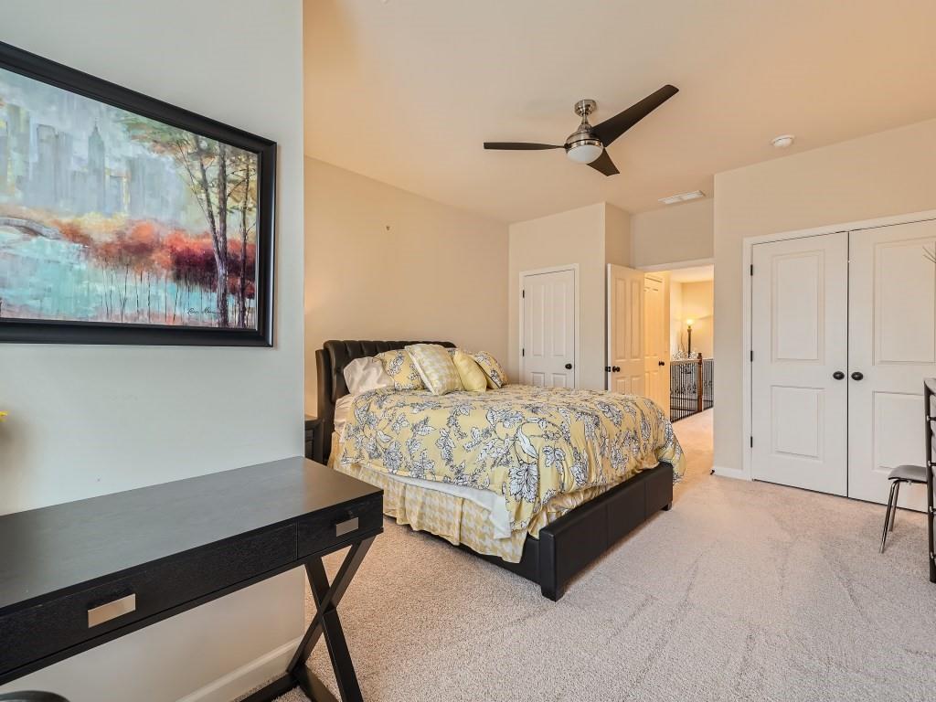 Carpeted bedroom featuring ceiling fan