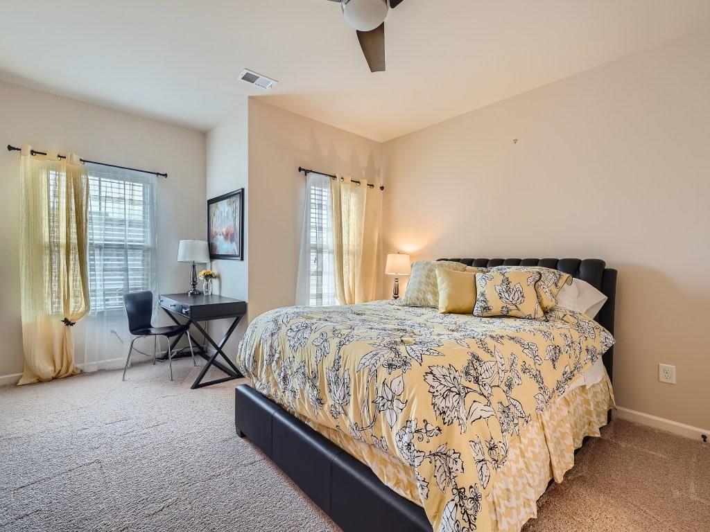 Carpeted bedroom featuring ceiling fan