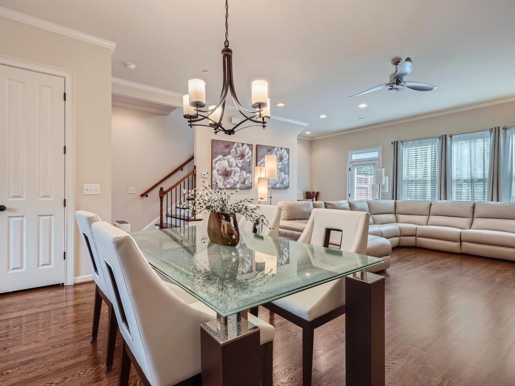 Dining space featuring crown molding, ceiling fan with notable chandelier, and dark hardwood / wood-style floors