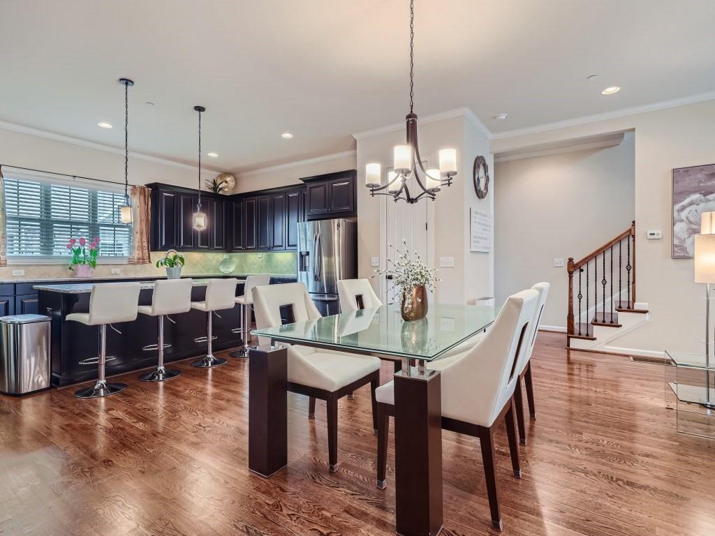 Dining area with crown molding, dark hardwood / wood-style floors, and a chandelier