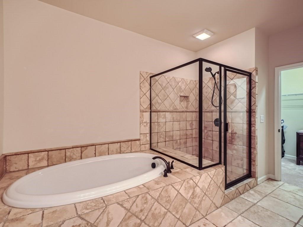 Bathroom with tile flooring and shower with separate bathtub