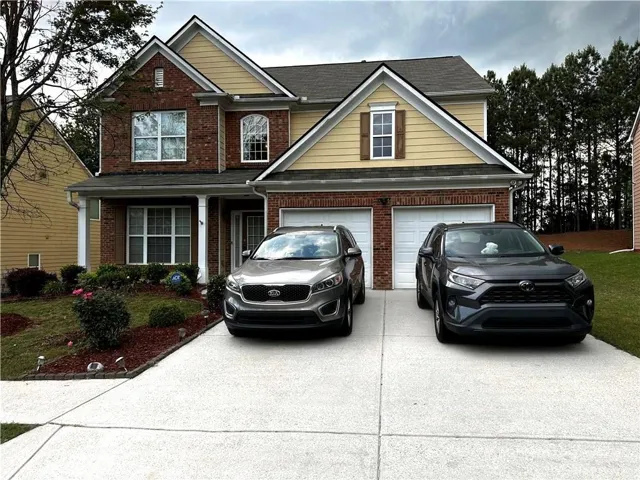 Brick and siding exterior with a two-car garage and level driveway